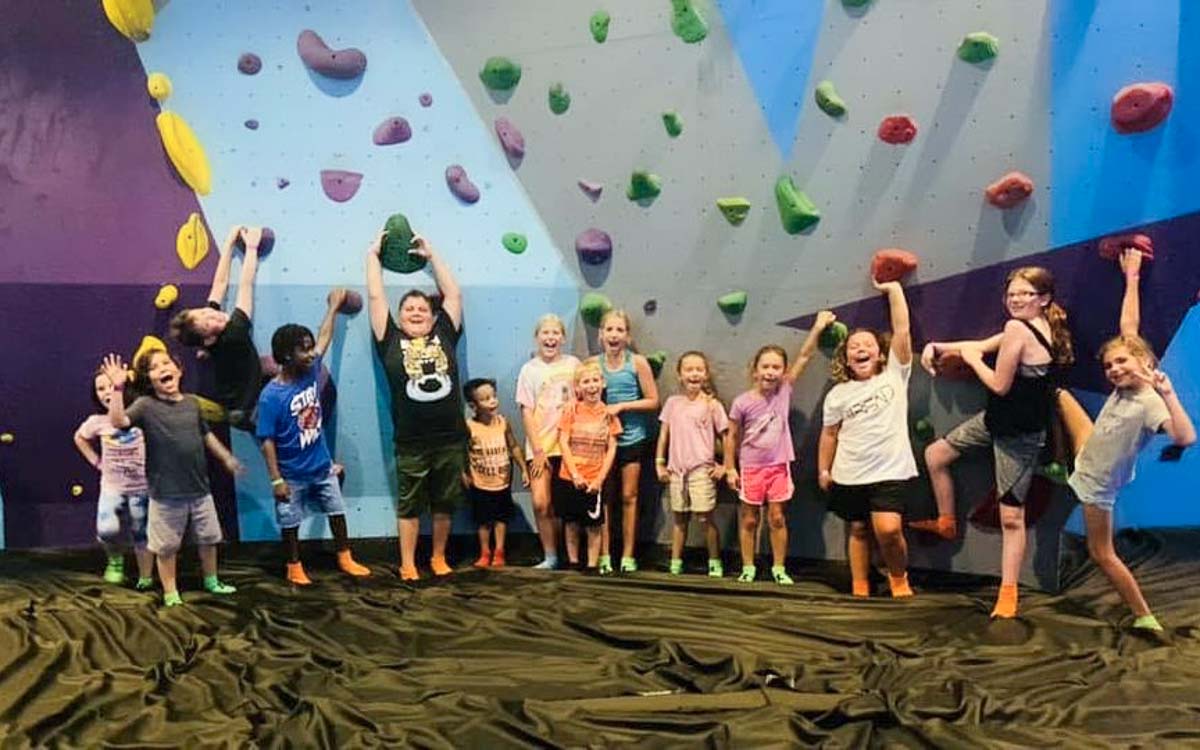 The Bend Kids in front of climbing wall